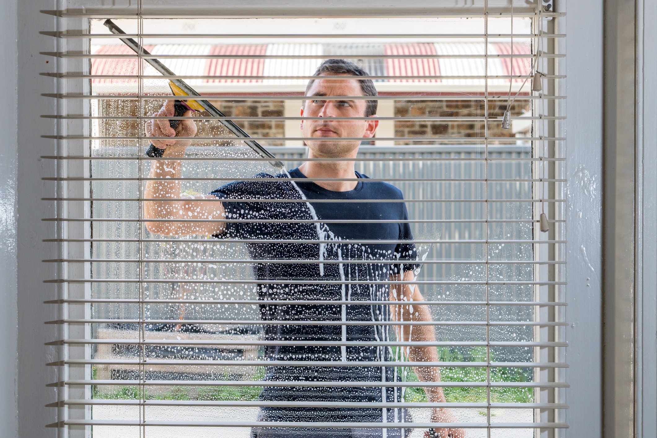 Inside view of a man washing a window Inside view of a man washing a window